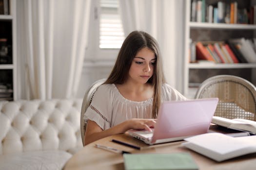 student studying with a laptop and books