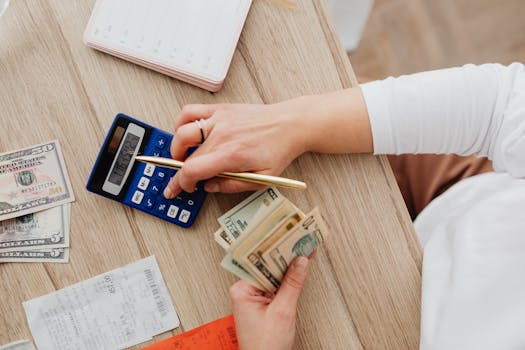 a person calculating budget with calculator