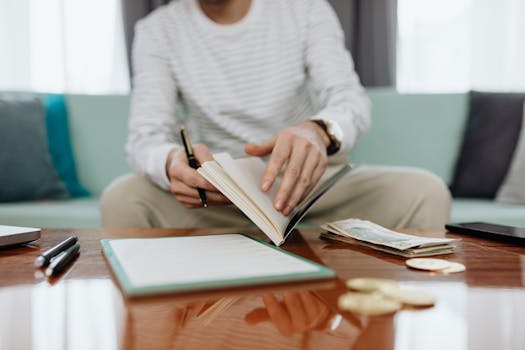 a person writing in a financial journal