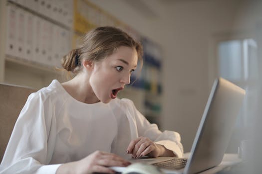 A student happily checking out discounts on a laptop